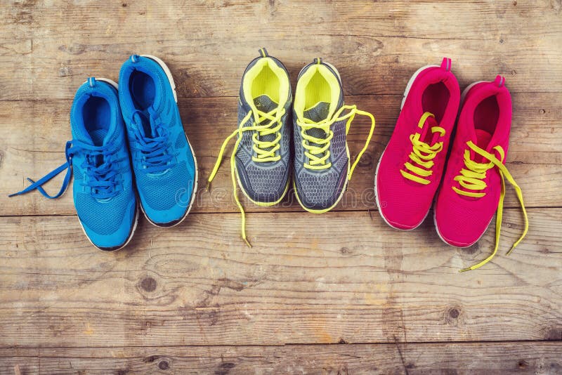 Various pairs of colorful sneakers laid on the wooden floor background. Various pairs of colorful sneakers laid on the wooden floor background