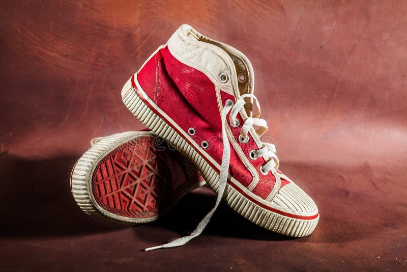 Zapatillas de deporte rojas y negras para niños zapatos para niños sobre un  fondo rojo.