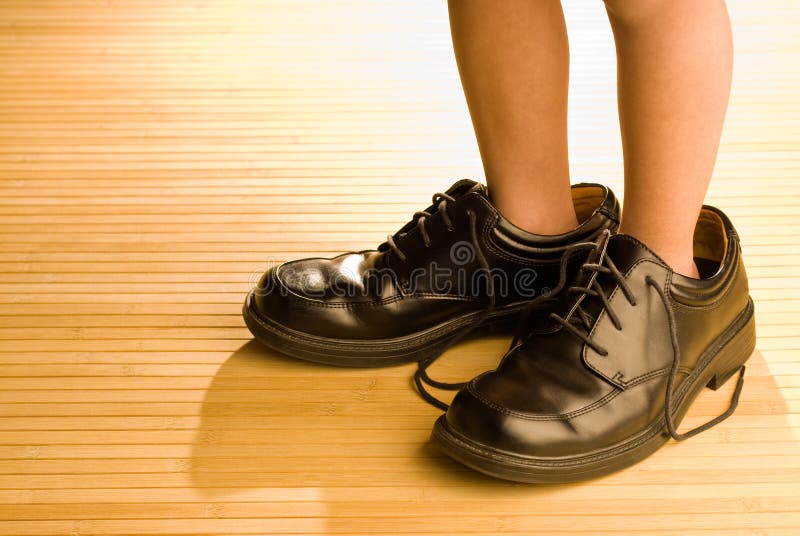 Zapatos grandes a llenar, pies del niño en zapatos negros grandes foto de archivo Zapatos grandes a llenar, pies del niño en zapatos negros grandes foto de archivo