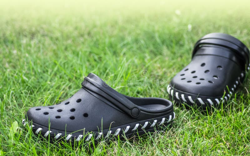 Zapatos negros del jardín del estilo de los crocs imagenes de archivo Zapatos negros del jardín del estilo de los crocs imagenes de archivo