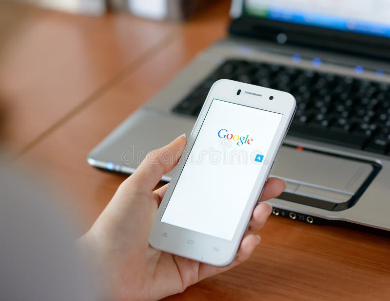 ZAPORIZHZHYA, DE OEKRAÏNE - JANUARI 23, 2015: Jonge Vrouw die Google-Webonderzoek op haar Slimme Telefoon gebruiken stock fotografie ZAPORIZHZHYA, DE OEKRAÏNE - JANUARI 23, 2015: Jonge Vrouw die Google-Webonderzoek op haar Slimme Telefoon gebruiken stock fotografie
