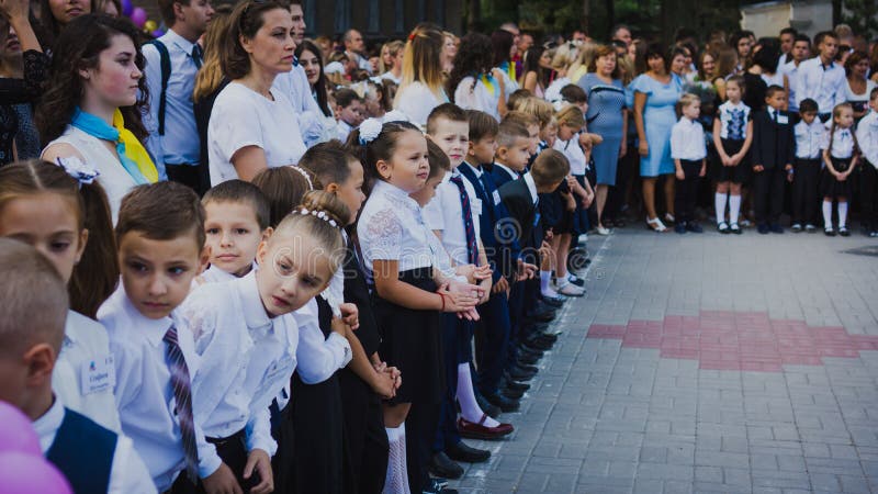 Zaporozhye, Ucrânia - 1º de setembro de 2018: os primeiro-graduadores estão em uma régua no ar livre com professores e High Schoo fotos de stock Zaporozhye, Ucrânia - 1º de setembro de 2018: os primeiro-graduadores estão em uma régua no ar livre com professores e High Schoo fotos de stock