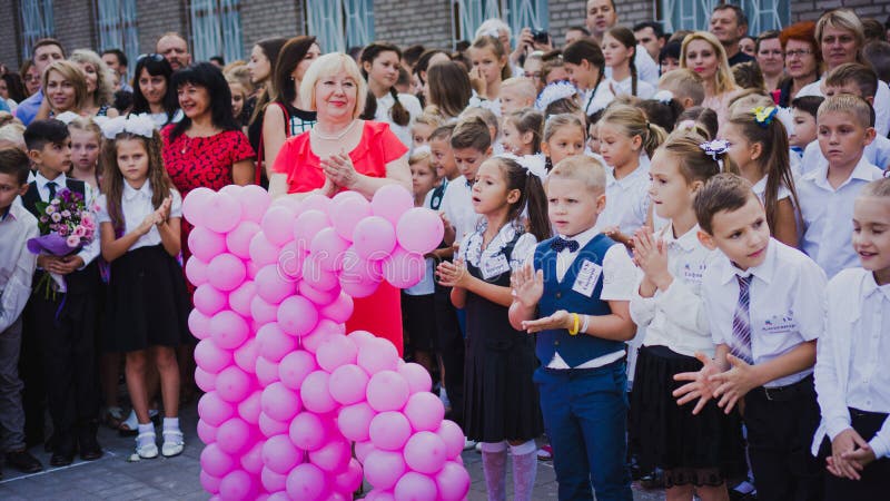 Zaporozhye, Ukraine - 1er septembre 2018 : les premier-niveleuses se tiennent sur une règle en plein air avec des professeurs et image libre de droits Zaporozhye, Ukraine - 1er septembre 2018 : les premier-niveleuses se tiennent sur une règle en plein air avec des professeurs et image libre de droits