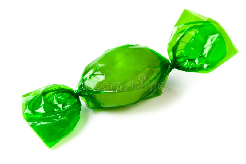 The green candy wrapped in foil on white background. The green candy wrapped in foil on white background