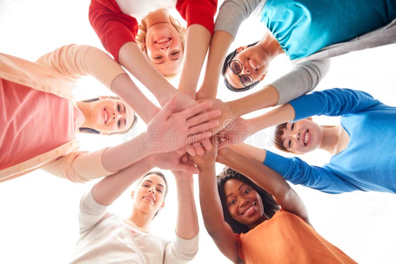 Diversity, race, ethnicity and people concept - international group of happy smiling different women over white holding hands together. Diversity, race, ethnicity and people concept - international group of happy smiling different women over white holding hands together