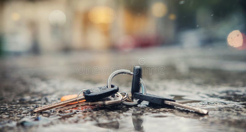 Zbiór zgubionych kluczy na pierścieniu na mokrym gruncie na ulicy