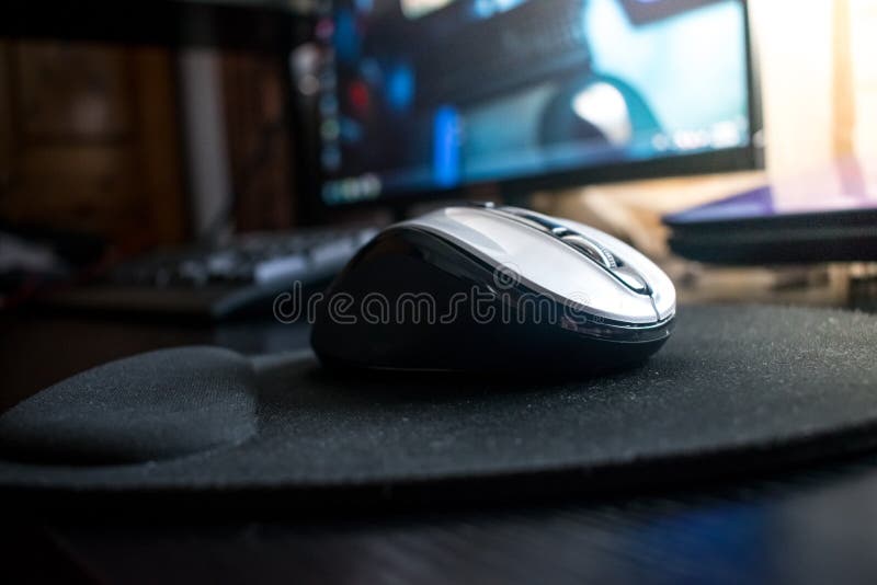 Zbliżenie Bezprzewodowa Bluetooth komputerowa mysz na czarnym biurku z myszą obrazy stock Zbliżenie Bezprzewodowa Bluetooth komputerowa mysz na czarnym biurku z myszą obrazy stock
