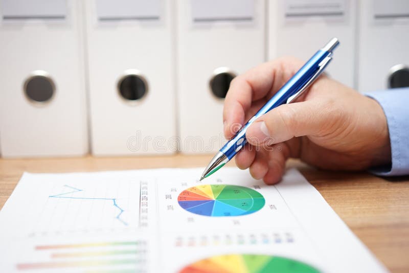 Zbliżenie biznesowego mężczyzna ręka analizuje różnorodne pieniężne mapy zdjęcia stock Zbliżenie biznesowego mężczyzna ręka analizuje różnorodne pieniężne mapy zdjęcia stock