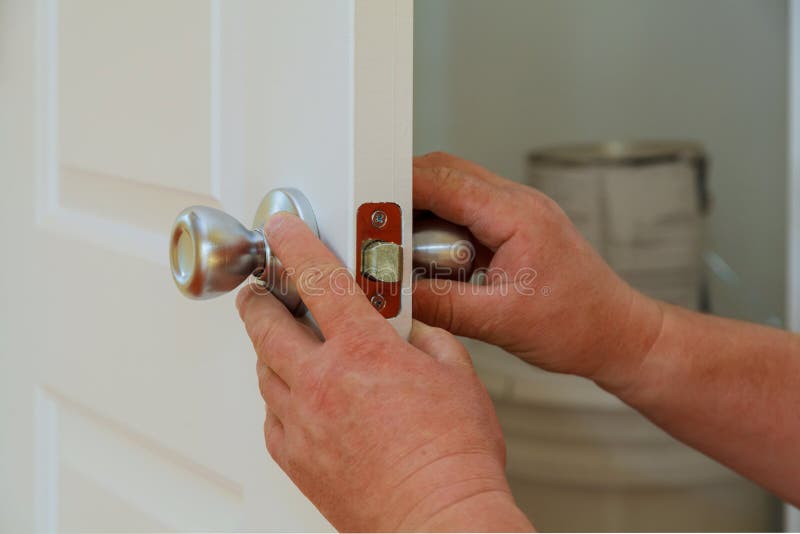 Zbliżenie fachowy locksmith instaluje nowego deadbolt kędziorek lub naprawia obraz royalty free Zbliżenie fachowy locksmith instaluje nowego deadbolt kędziorek lub naprawia obraz royalty free