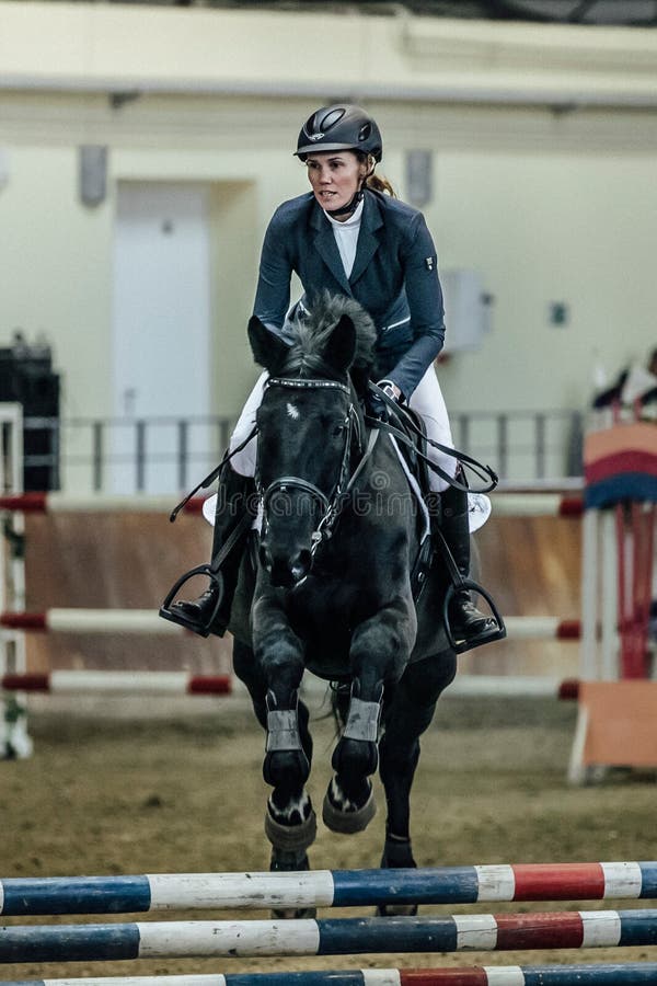 Zbliżenie kobiety jeźdza koń pokonuje przeszkoda sportów kompleks indoors obrazy stock Zbliżenie kobiety jeźdza koń pokonuje przeszkoda sportów kompleks indoors obrazy stock