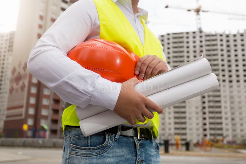 Zbliżenie pozuje z hardhat i projektami dalej młody architekt zdjęcie stock
