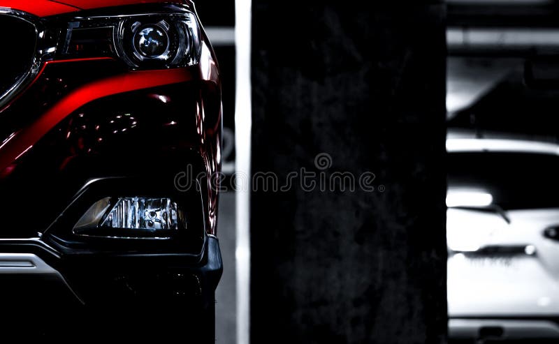 Zbliżenie reflektory czerwony SUV sportowy samochód parkowali blisko betonowego słupa przy salowym parking Headlamp światła z ele obraz royalty free Zbliżenie reflektory czerwony SUV sportowy samochód parkowali blisko betonowego słupa przy salowym parking Headlamp światła z ele obraz royalty free