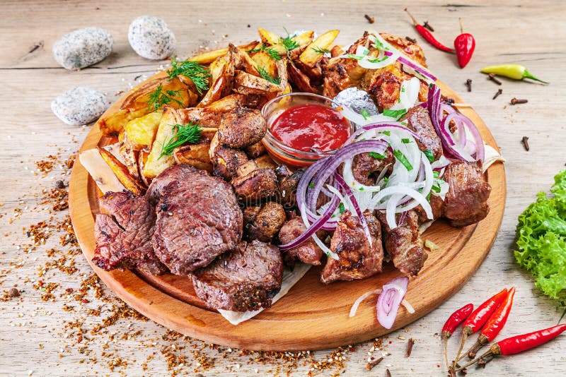 Zbliżenie widok na secie piec na grillu mięso i warzywa słuzyć na drewnianej porcji desce na stole z ziele pikantność Grill wiepr obraz royalty free Zbliżenie widok na secie piec na grillu mięso i warzywa słuzyć na drewnianej porcji desce na stole z ziele pikantność Grill wiepr obraz royalty free