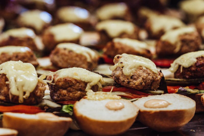 Zbliżenie widok Pokrojony chleba rozszerzanie się na stole z składnikami na one dla Małych hamburgerów - kuchnia set, pojęcie wak zdjęcie royalty free Zbliżenie widok Pokrojony chleba rozszerzanie się na stole z składnikami na one dla Małych hamburgerów - kuchnia set, pojęcie wak zdjęcie royalty free