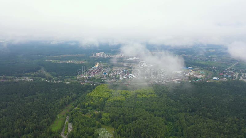 Zbor aerian deasupra norului în stare proaspătă de dimineață cu zone industriale înconjurate de păduri în fundal. stock footage
