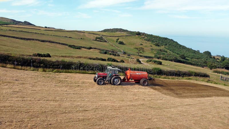 Aerial Photo of Massey Ferguson 390T Tractor Abbey Tanker spreading manure in a field on a farm in the UK 02-02-22. Aerial Photo of Massey Ferguson 390T Tractor Abbey Tanker spreading manure in a field on a farm in the UK 02-02-22