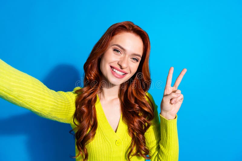 Zdjęcie portret atrakcyjnej młodej kobiety zrobić selfie foto vsign ubrany stylowo żółty ubrania wyizolowany w niebieskim kolorze zdjęcie royalty free