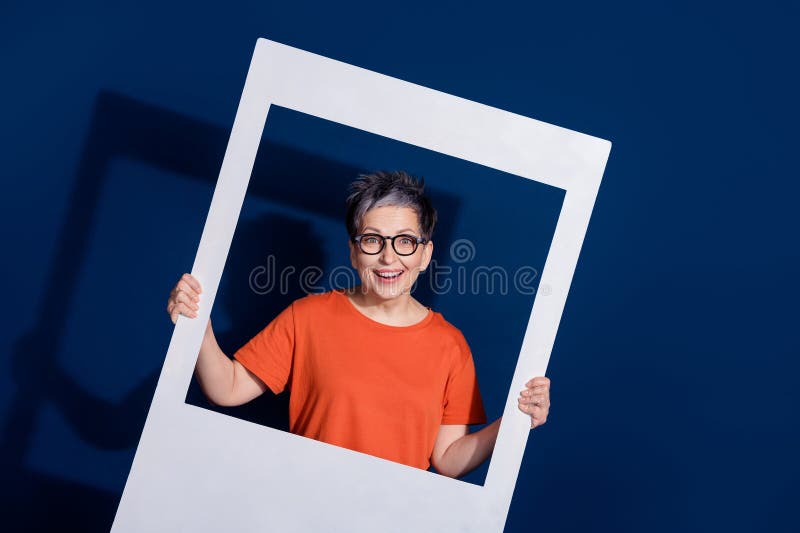 Zdjęcie portret całkiem emerytowanej kobiety trzymanie natychmiastowe zdjęcie ramka nosić modny pomarańczowy strój w ciemno niebie zdjęcie royalty free