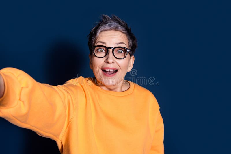 Zdjęcie portret uroczej emeryckiej pani zdumionej zrobić selfie zdjęcie ubrany stylowo żółty odzież wyizolowany na ciemno niebiesk obraz stock