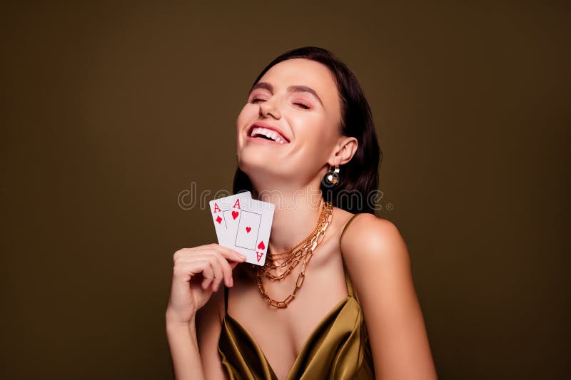 Zdjęcie wesołej eleganckiej kobiety trzymającej karty w pełnym domu i wygrywającej grę oddzielone brązowym kolorem tła fotografia stock