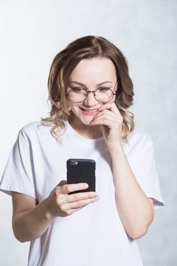 Zdumiony i zmartwiony, pi?kna m?oda kobieta trzyma smartphone, gapi si? z zdziwionym wyra?eniem zdjęcie stock Zdumiony i zmartwiony, pi?kna m?oda kobieta trzyma smartphone, gapi si? z zdziwionym wyra?eniem zdjęcie stock
