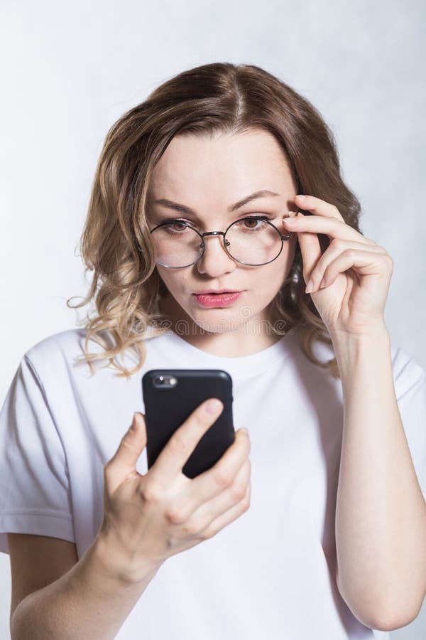 Zdumiony i zmartwiony, pi?kna m?oda kobieta trzyma smartphone, gapi si? z zdziwionym wyra?eniem zdjęcie royalty free Zdumiony i zmartwiony, pi?kna m?oda kobieta trzyma smartphone, gapi si? z zdziwionym wyra?eniem zdjęcie royalty free