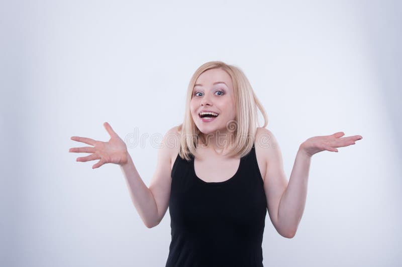 Zdziwiona emocjonalna kobieta jest uśmiechnięta i rozprzestrzenia out ona ręki Portret ładny blondynki dziewczyny ono uśmiecha si zdjęcie royalty free Zdziwiona emocjonalna kobieta jest uśmiechnięta i rozprzestrzenia out ona ręki Portret ładny blondynki dziewczyny ono uśmiecha si zdjęcie royalty free