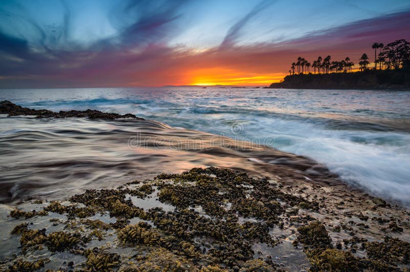 Long exposure of the Laguna Beach Coastline during an incredible sunset with streaky clouds. Long exposure of the Laguna Beach Coastline during an incredible sunset with streaky clouds