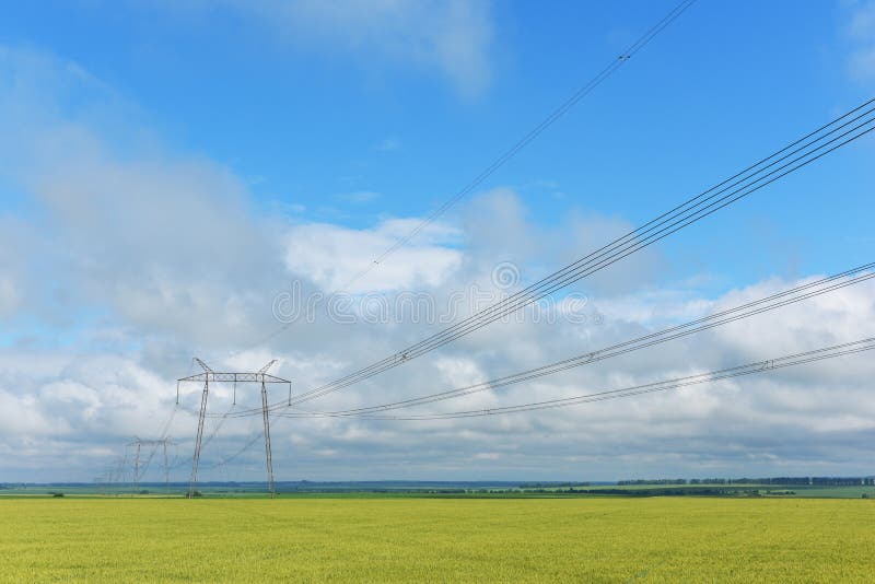 Zeer lange draden en de grote polen van de machtstransmissie stock foto Zeer lange draden en de grote polen van de machtstransmissie stock foto