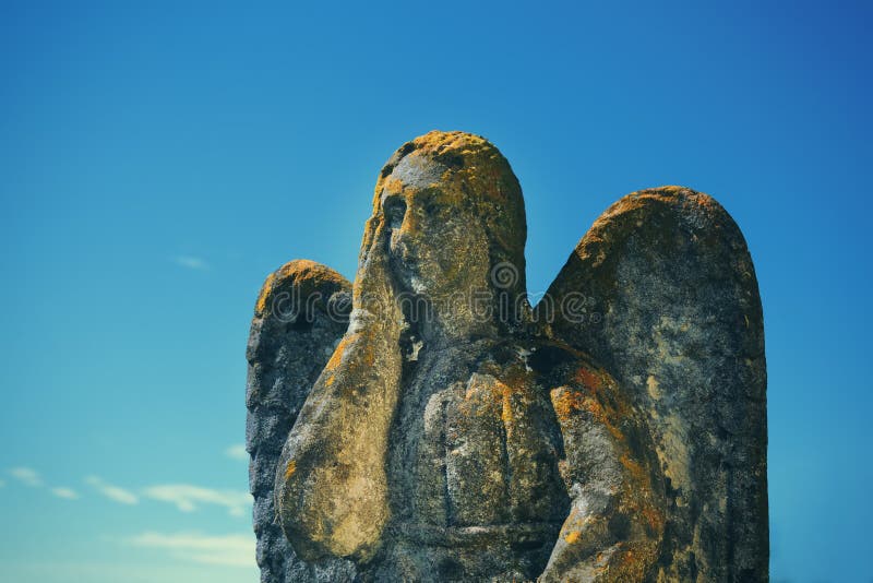 Zeer oud steenbeeld van mooie engel in mos stock afbeeldingen