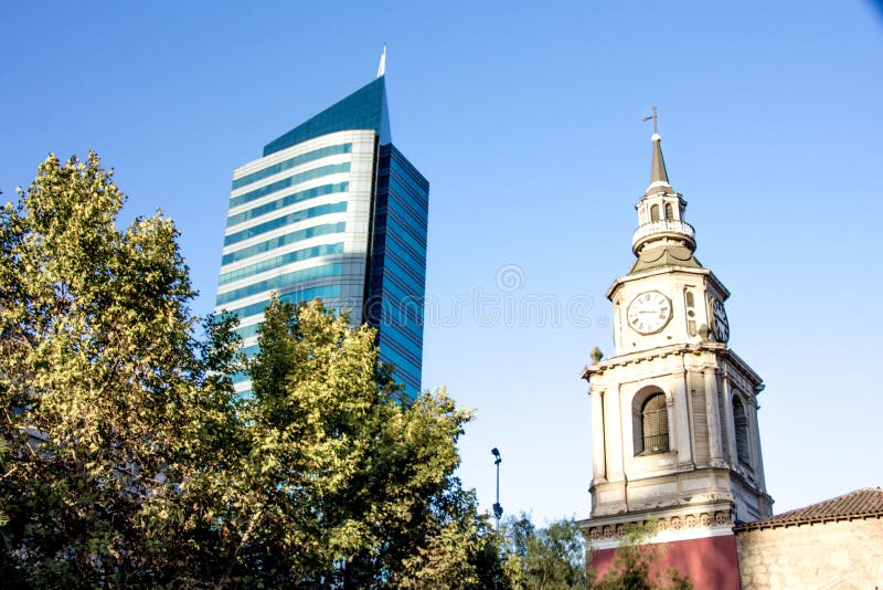 Zeer Oude kerktorenspits met klok, naast een ultra modern blauw gebouw royalty-vrije stock foto's Zeer Oude kerktorenspits met klok, naast een ultra modern blauw gebouw royalty-vrije stock foto's