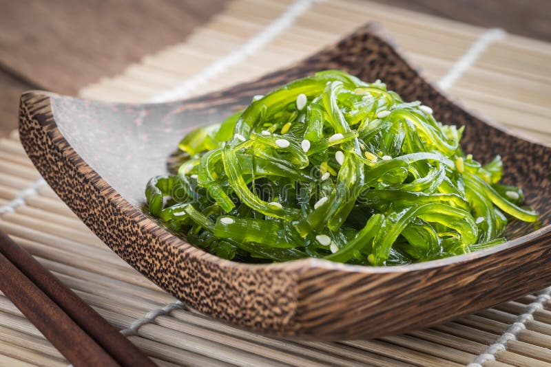 Zeewiersalade op houten plaat, Japanse keuken stock afbeelding Zeewiersalade op houten plaat, Japanse keuken stock afbeelding