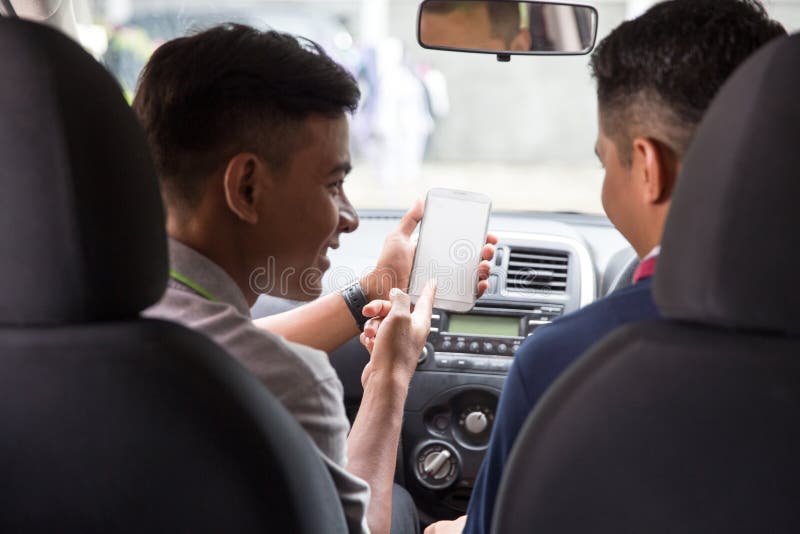 Zeigen seines Handys zum Autofahrer. Mann, der seinen Handy zum Autofahrer zeigt