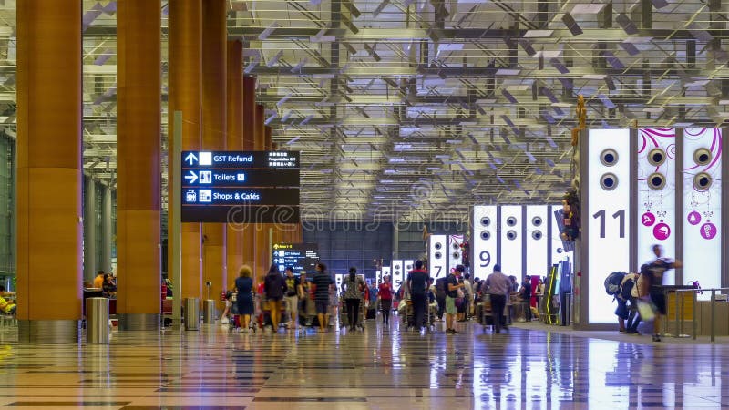 Zeit-Versehen: Besucher gehen um Abfahrt Hall in internationalem Flughafen Changi, Singapur
