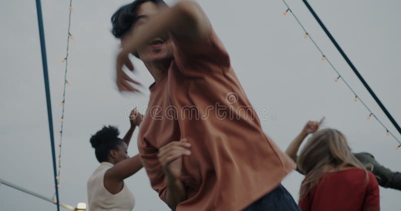 Zeitlupenportrait des gutheißenden asiatischen Mannes tanzt modernes Breakdance auf der Party im Freien entspannt mit Freunden