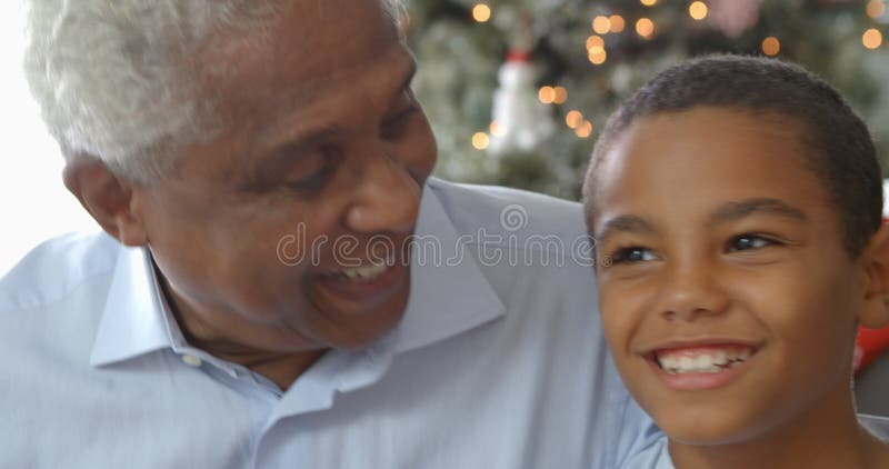 Zeitlupereihenfolge des Jungen sitzend auf Sofa mit Vater und Großvater zur Weihnachtszeit