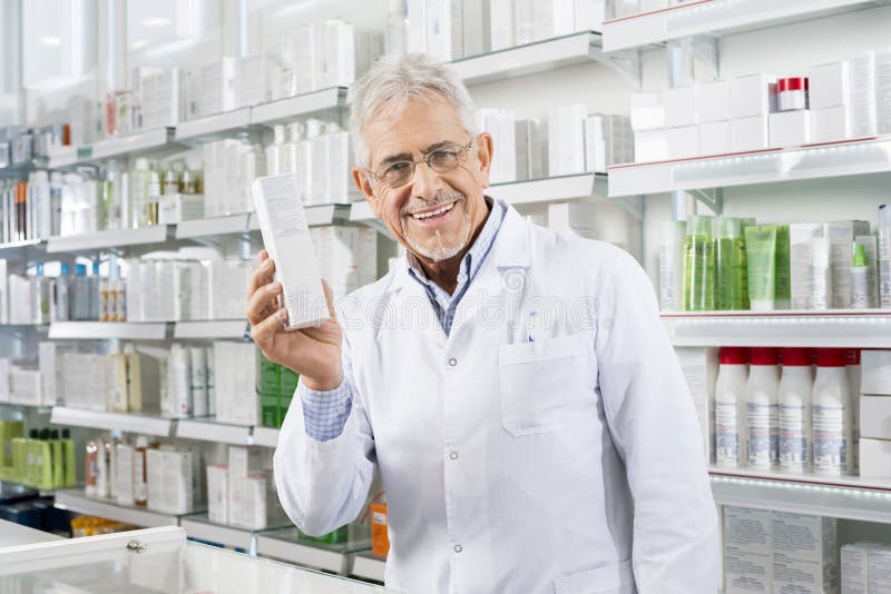 Zekere Apotheker Holding Medicine Box in Apotheek stock foto's Zekere Apotheker Holding Medicine Box in Apotheek stock foto's