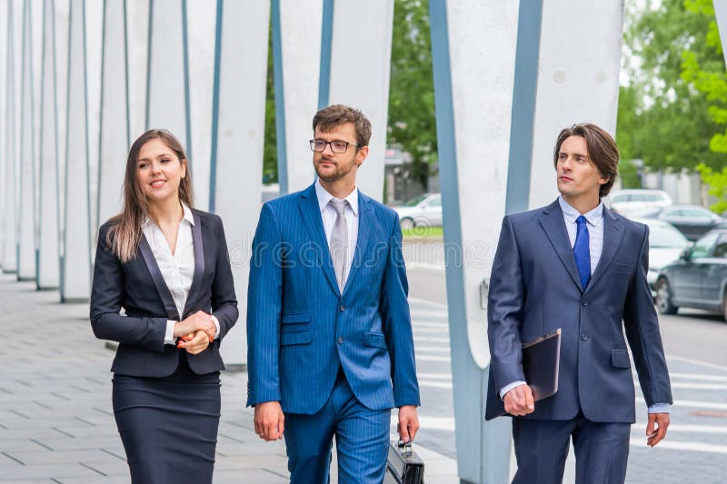 Zekere businesspersons die voor de moderne bureaubouw spreken De zakenlieden en de onderneemster hebben zaken royalty-vrije stock afbeeldingen Zekere businesspersons die voor de moderne bureaubouw spreken De zakenlieden en de onderneemster hebben zaken royalty-vrije stock afbeeldingen