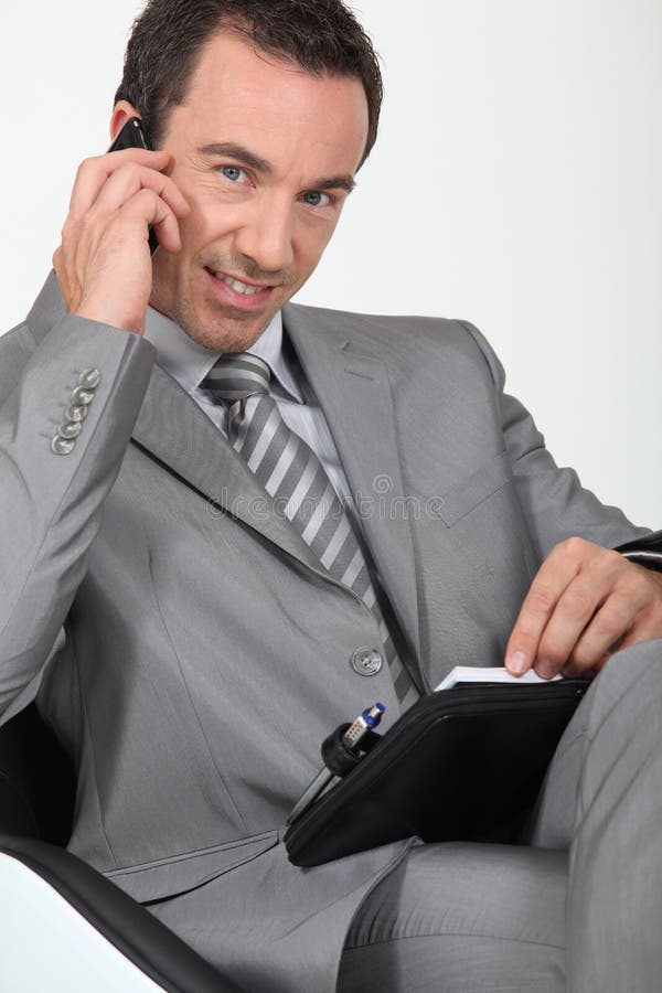 Confident male executive with mobile phone and diary. Confident male executive with mobile phone and diary