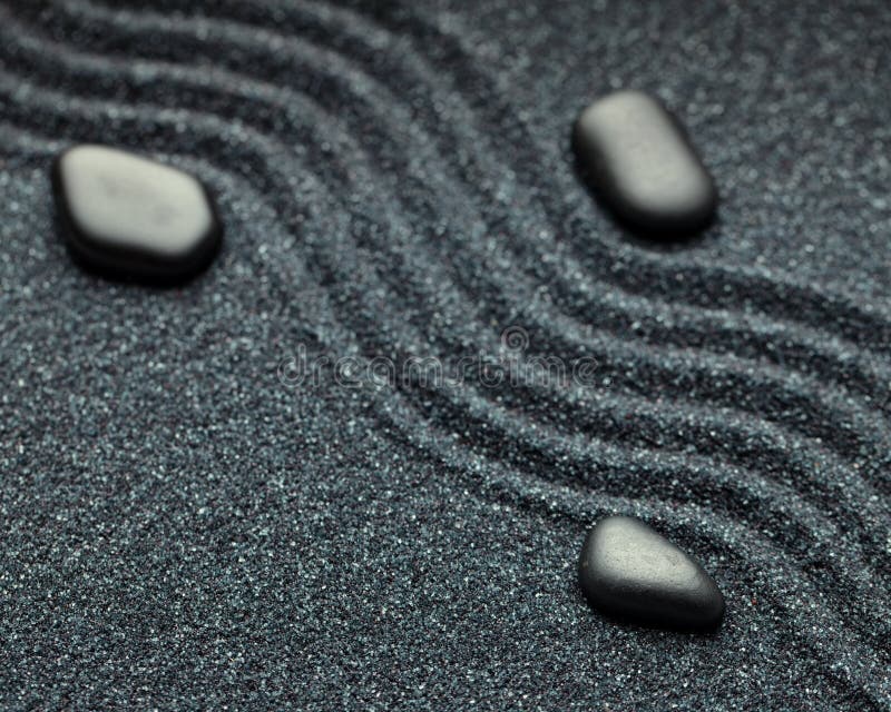 zen-garden-wave-lines-sand-black-rocks-dark-61683707.jpg