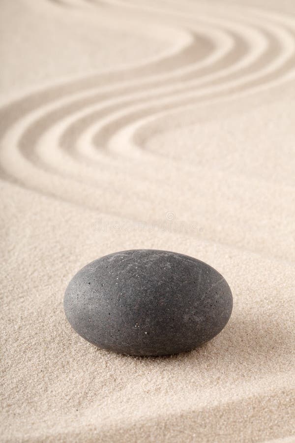 Zengarten mit geharktem Sand und runder Meditationsstein für Konzentration und Fokus lizenzfreie stockfotografie