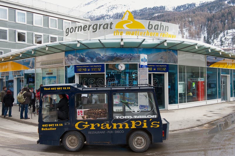 Gornergratbahn train station with electric taxi passing by in Zermatt, Switzerland.