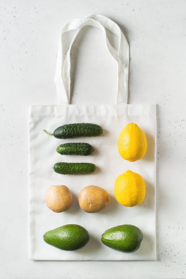 Zero waste concept. Textile ecologiical shopping bags with fruits and vegetables on white background