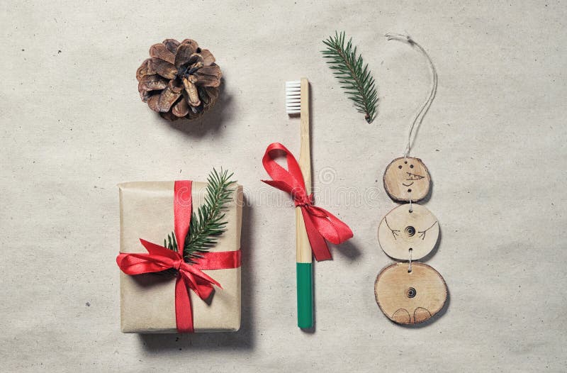 Zero waste plastic free christmas gift flatlay. Bamboo toothbrush, gift box wrap in craft paper, handmade xmas natural decoration