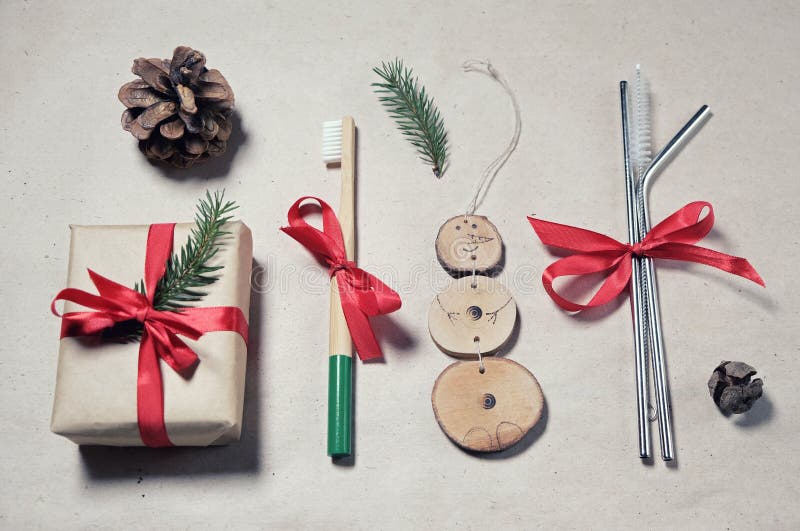 Zero waste plastic free christmas gift flatlay. Bamboo toothbrush, reusable metal straws, gift box wrap in craft paper, handmade