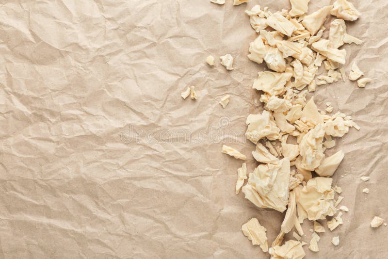 Zerquetschte weiße Schokolade bessert auf zerknittertem Kraftpapier, Draufsicht aus lizenzfreie stockfotografie Zerquetschte weiße Schokolade bessert auf zerknittertem Kraftpapier, Draufsicht aus lizenzfreie stockfotografie