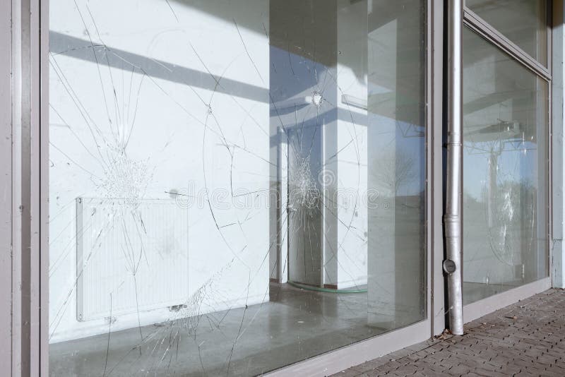 Vandalized broken windows of a retail building. Vandalized broken windows of a retail building