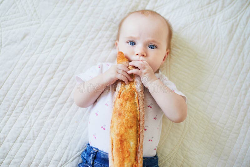Zes van het babymaanden oud meisje die brood eten royalty-vrije stock foto's Zes van het babymaanden oud meisje die brood eten royalty-vrije stock foto's
