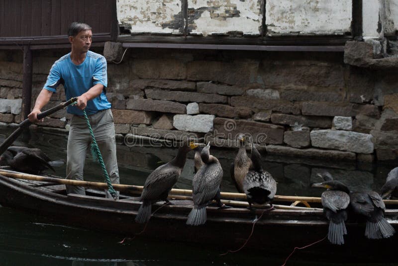 ZHOUZHUANG, ΚΙΝΑ: Helmsman που οδηγεί τη βάρκα που περνά μέσω των καναλιών στοκ εικόνες με δικαίωμα ελεύθερης χρήσης ZHOUZHUANG, ΚΙΝΑ: Helmsman που οδηγεί τη βάρκα που περνά μέσω των καναλιών στοκ εικόνες με δικαίωμα ελεύθερης χρήσης