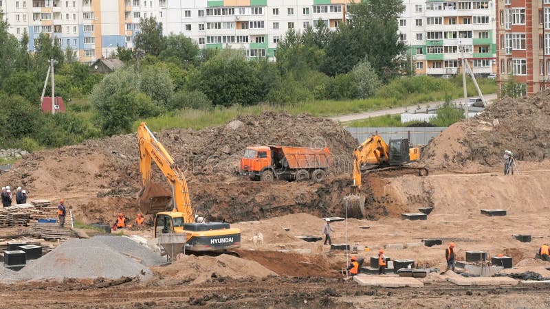 Ziegelsteine, die draußen legen Bagger lädt Lehm in LKW